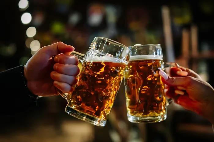 Two people clinking beer glasses