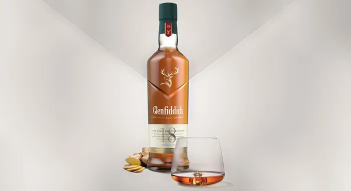 Bottle of Glenfiddich 18 year next to a tumbler glass of whisky
