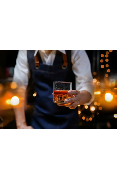 lifestyle image: a bartender handing a glass of single malt whisky to you