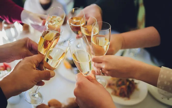 7 glasses of Champagne being clinked together during a toast at a fancy event